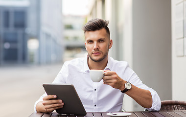 Image showing man with tablet pc and coffee at city cafe