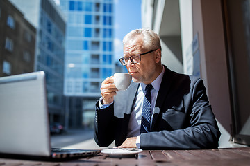 Image showing senior businessman with laptop drinking coffee