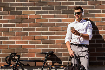 Image showing man with headphones, smartphone and bicycle