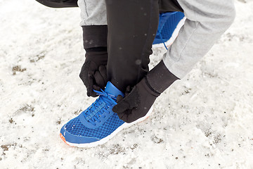 Image showing close up of man tying shoe lace in winter outdoors