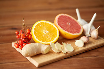 Image showing citrus, ginger, garlic and rowanberry on wood