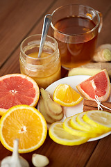 Image showing ginger tea with honey, citrus and garlic on wood