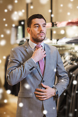 Image showing young man trying suit on in clothing store