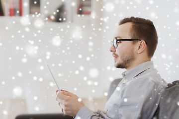 Image showing man with tablet pc at home over snow