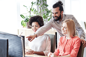 Image showing happy creative team with computer in office