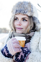 Image showing young pretty teenage hipster girl outdoor in winter snow park having fun drinking coffee, warming up happy smiling, lifestyle people concept