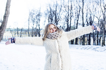 Image showing young pretty teenage hipster girl outdoor in winter snow park having fun drinking coffee, warming up happy smiling, lifestyle people concept