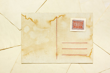 Image showing Aged empty postcard with painted abstract postage stamp