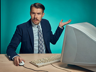 Image showing Surprised Young Man Working On computer At Desk