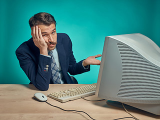 Image showing Sad Young Man Working On computer At Desk