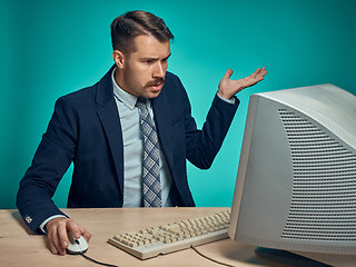 Image showing Surprised Young Man Working On computer At Desk