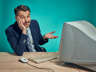 Image showing Sad Young Man Working On computer At Desk