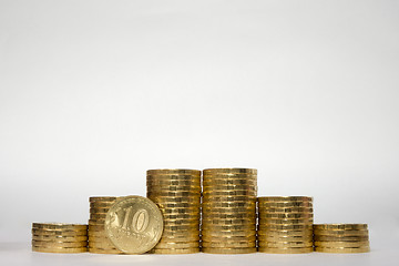 Image showing Six stacks of coins increasing height symmetrically on a white background, pockmarked stands on the edge of the Russian 10 ruble coin