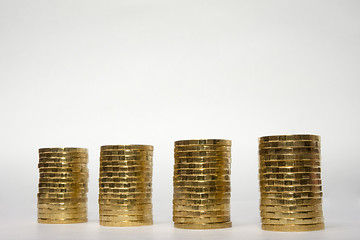 Image showing Four stacks of coins on a light background