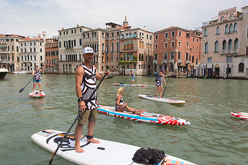 Image showing Group of active tourists stand up paddling on sup boards at Grand Canal, Venice, Italy.