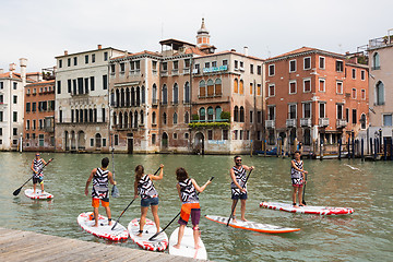Image showing Group of active tourists stand up paddling on sup boards at Grand Canal, Venice, Italy.