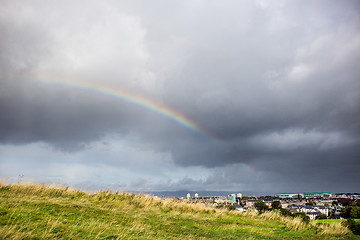 Image showing cloudy sky and rainbow above the city