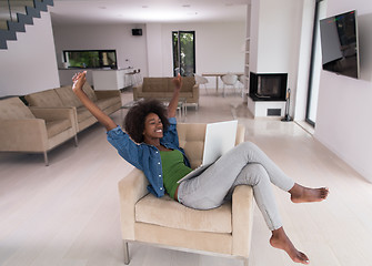 Image showing African American women at home in the chair using a laptop