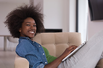 Image showing African American women at home in the chair using a laptop