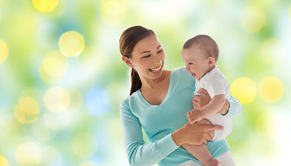 Image showing happy mother with little baby over green lights