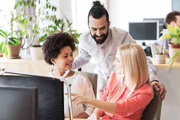 Image showing happy creative team with computer in office