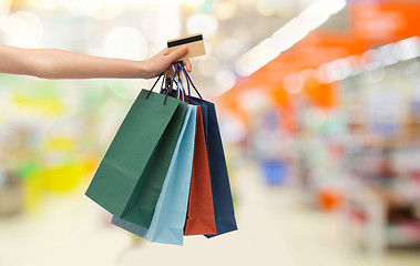 Image showing hand with shopping bags and credit card at store