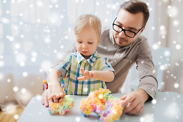 Image showing father and son playing with ball clay at home