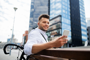 Image showing happy man with smartphone and bicycle in city