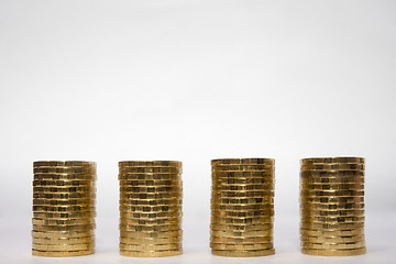 Image showing Four identical height of the stack of coins on a light background, the top place for an inscription