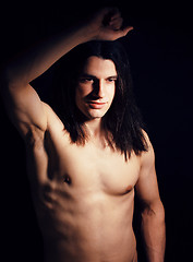 Image showing handsome young man with long hair naked torso on black background