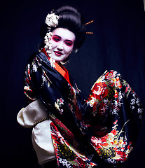 Image showing young pretty geisha in kimono with sakura and decoration