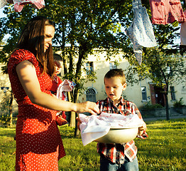Image showing woman with children in garden hanging laundry