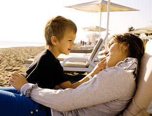 Image showing young mother with son resting on sea coast, happy family togethe