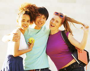 Image showing cute group of teenages at the building of university with books huggings