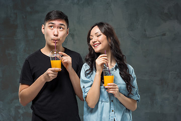 Image showing A young pretty Asian couple with a glasses of Orange juice