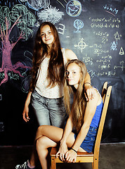 Image showing back to school after summer vacations, two teen girls in classroom with blackboard painted