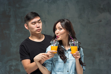 Image showing A young pretty Asian couple with a glasses of Orange juice