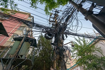 Image showing Large mount of power cables on wooden pylon