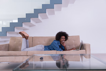 Image showing African American woman using laptop on sofa