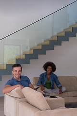 Image showing multiethnic couple relaxing at  home with tablet computers