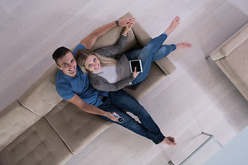 Image showing youg couple in living room with tablet top view