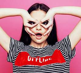 Image showing young pretty teenage woman emotional posing on pink background, fashion lifestyle people concept 