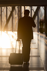 Image showing Businessman at airport corridor walking to departure gates.