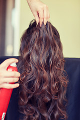 Image showing stylist with hair spray making hairdo at salon