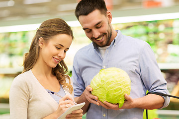 Image showing couple with notebook and cabbage at grocery store