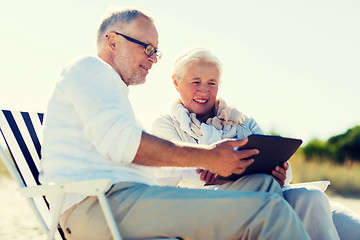 Image showing happy senior couple with tablet pc on summer beach