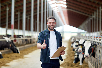 Image showing farmer with cows showing thumbs up on dairy farm