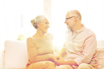 Image showing happy senior couple hugging on sofa at home