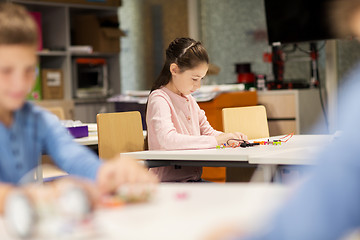 Image showing happy girl building robot at robotics school