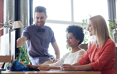 Image showing happy creative team with computer in office